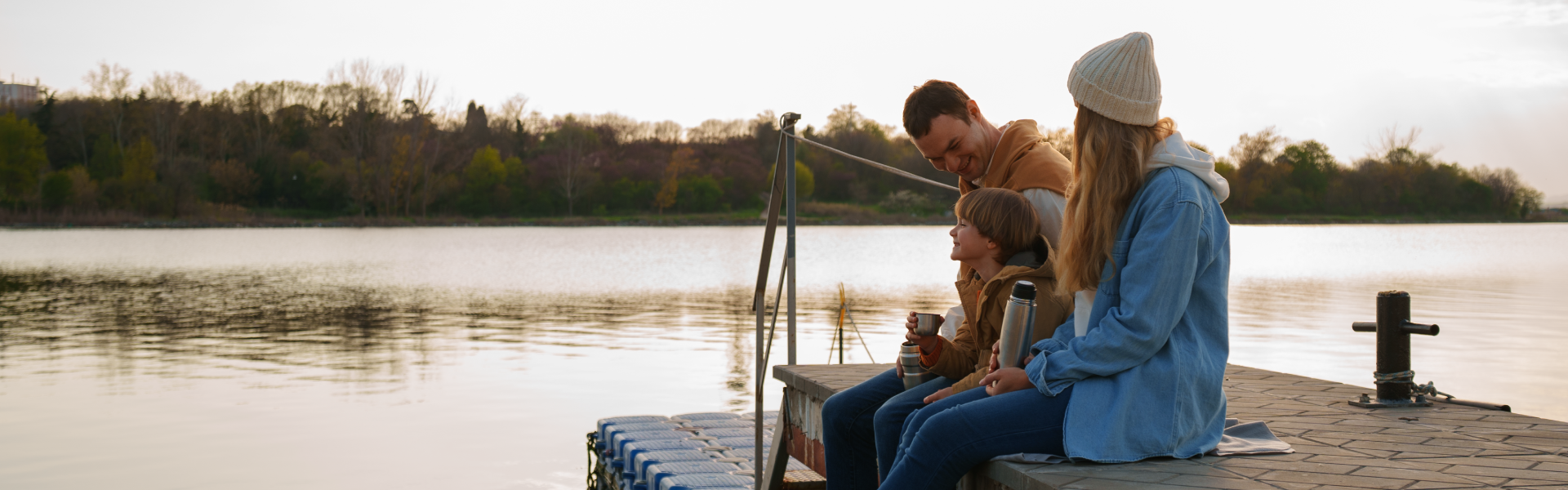 family sitting on dock fishing in fall